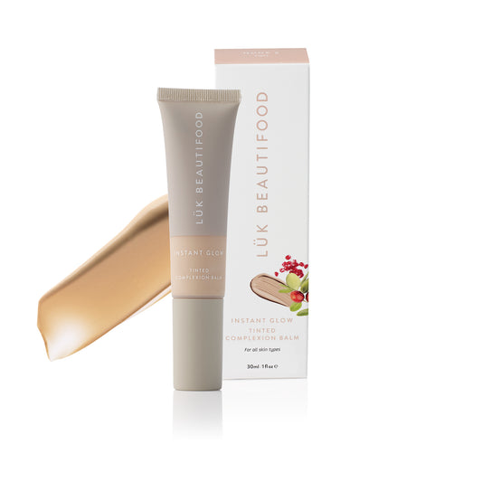 LÜK Beautifood Instant Glow Skin Tint in Nude 2 Light, tube and box with a swatch of the tinted complexion balm